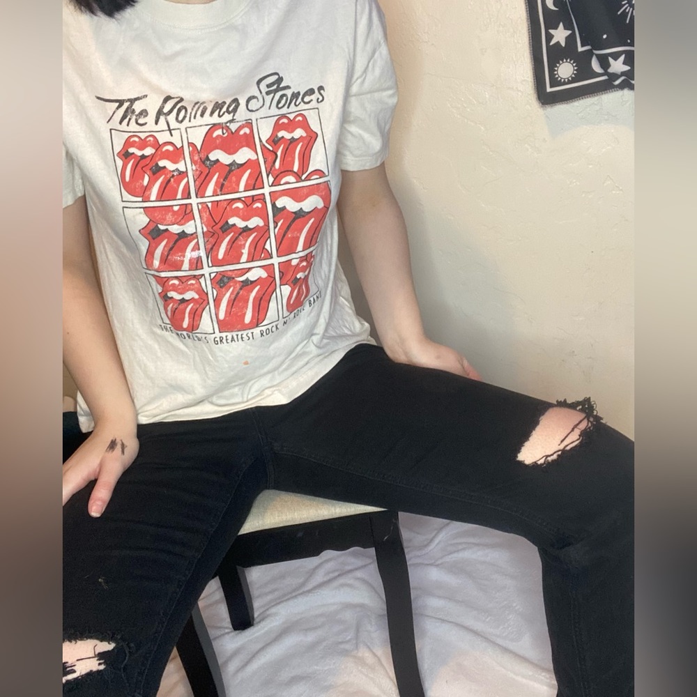 Matching set of black ripped jeans and a large rolling stone top